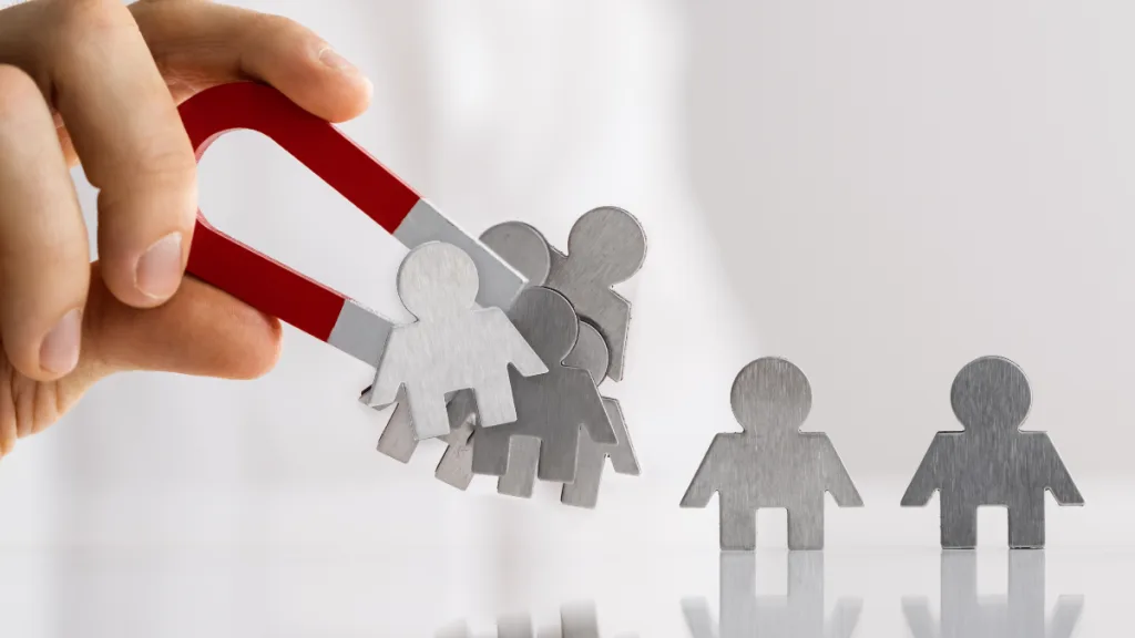 Illustration of a hand holding a magnet, attracting multiple people icons